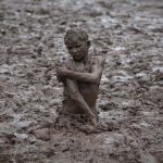 A boy plays in the mud near the Ravi river after a downpour on the outskirts of Lahore